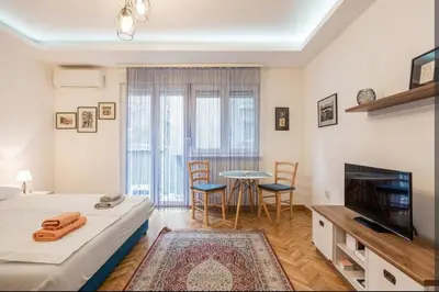 a room with a bed and a tv and a table at Balkan-inn Apartment Terazije 2 in Belgrade