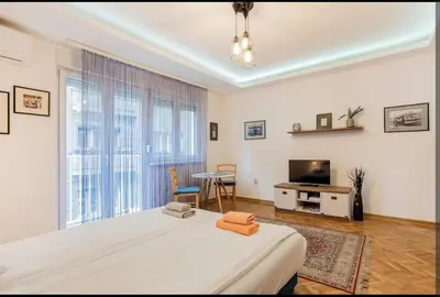 a bedroom with a bed and a television and a table at Balkan-inn Apartment Terazije 2 in Belgrade