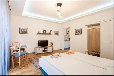a bedroom with a bed and a desk and a television at Balkan-inn Apartment Terazije 2 in Belgrade