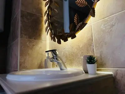 a bathroom sink with a faucet and a mirror at Cosy Retreat 135 in Belgrade