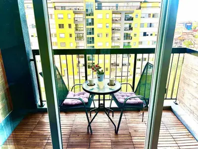 a balcony with a table and chairs on a balcony at Cosy Retreat 135 in Belgrade