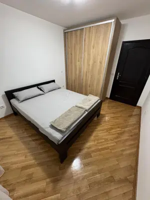 a bedroom with a bed and a wooden floor at Apartman Centar in Obrenovac