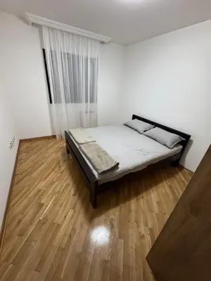 a bedroom with a bed and a wooden floor at Apartman Centar in Obrenovac