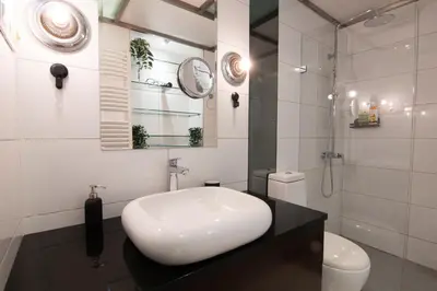 a white bathroom with a sink and a shower at Astra Apartment in Belgrade