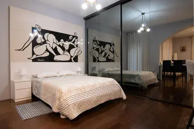 a bedroom with a large bed and a mirror at Astra Apartment in Belgrade