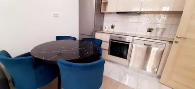 a kitchen with a black table and blue chairs at Apartman Vojvoda in Belgrade