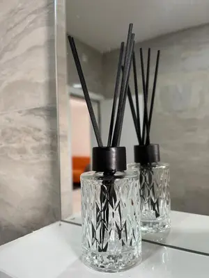 two glass vases with sticks in them on a table at Airport Art Villa in Surčin