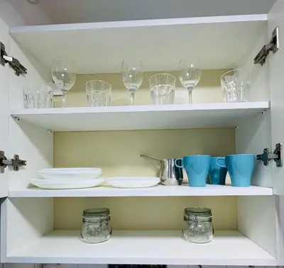 a shelf with wine glasses and plates on it at Vračarska kućica in Belgrade