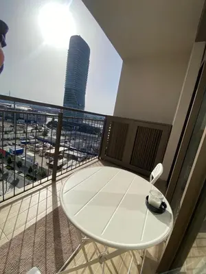 a balcony with a table and a view of a skyscraper at BW Arcadia Apartments - Beograd na vodi in Belgrade