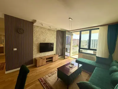 a living room with a green couch and a television at Q4 Comfort Apartment in Belgrade