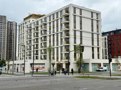 a large white building on a city street with people at Q4 Comfort Apartment in Belgrade