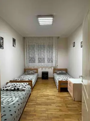two beds in a room with a window and a sink at Sunlight House in Belgrade