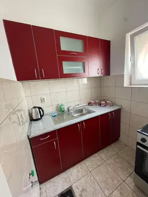 a kitchen with red cabinets and a sink at Sunlight House in Belgrade