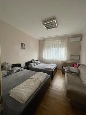 a bedroom with two beds and a couch at Sunlight House in Belgrade