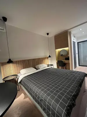 a bedroom with a large bed and a table at Apartment Cvijiceva - Park view in Belgrade