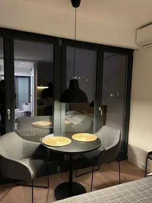 a room with a table and chairs and a bedroom at Apartment Cvijiceva - Park view in Belgrade
