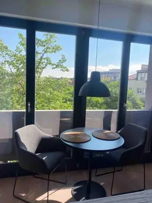 a table and chairs in front of a window at Apartment Cvijiceva - Park view in Belgrade