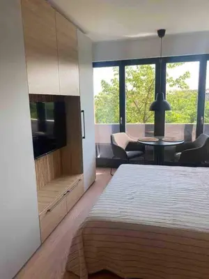 a bedroom with a large bed and a living room at Apartment Cvijiceva - Park view in Belgrade
