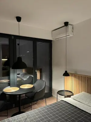 a bedroom with a bed and a table and chairs at Apartment Cvijiceva - Park view in Belgrade