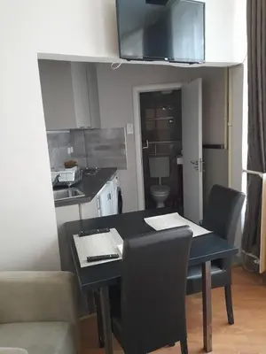 a kitchen with a black table and chairs in a room at Visoki Stevan Apartments in Belgrade