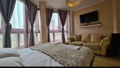 a bedroom with a bed and a couch and a television at Visoki Stevan Apartments in Belgrade