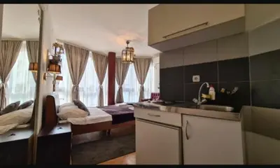 a kitchen with a sink and a room with two beds at Visoki Stevan Apartments in Belgrade