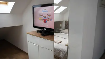 a room with a tv on a dresser with a bed at Jacuzzi Sensation in Belgrade