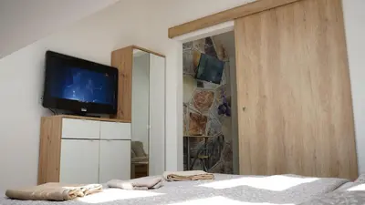 a bedroom with a tv on a dresser with a bed at Jacuzzi Sensation in Belgrade