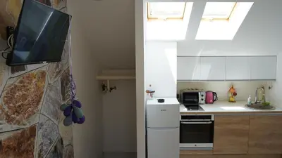 a kitchen with a tv hanging on a wall at Jacuzzi Sensation in Belgrade