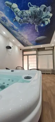 a room with a bath tub with a painting on the ceiling at Jacuzzi Sensation in Belgrade