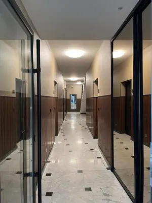a hallway in a building with glass doors and a corridor at Magnolia in Belgrade