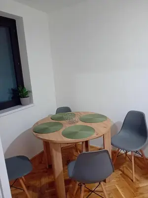a dining room table with four chairs around it at Apartman Tanja in Arandjelovac
