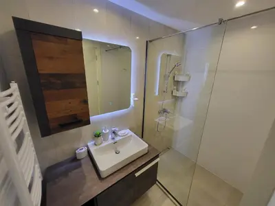 a bathroom with a sink and a shower with a mirror at BW Aqua LUX, river view, parking free in Belgrade