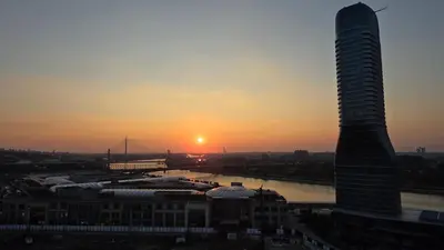 a sunset over a city with a tall building at BW Aqua LUX, river view, parking free in Belgrade
