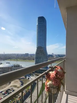a view of a tall building with flowers on a balcony at BW Aqua LUX, river view, parking free in Belgrade