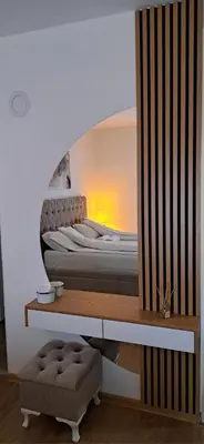 a bedroom with a bed with a mirror on the wall at Apartman Lučiano Aranđelovac in Arandjelovac