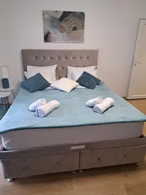 a bed with three pillows on top of it at Apartman Lučiano Aranđelovac in Arandjelovac