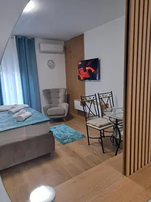 a living room with a bed and a dining room at Apartman Lučiano Aranđelovac in Arandjelovac