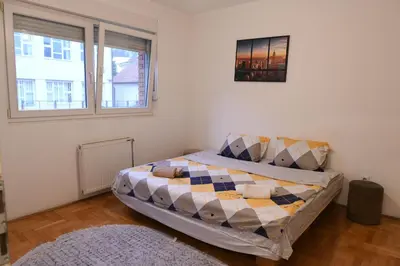 a bedroom with a bed with a quilt on it at Apartman Liberty in Belgrade