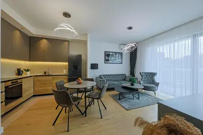 a kitchen and living room with a table and chairs at ZIGZAG Belgrade Waterfront - SIMFONIJA 2 in Belgrade