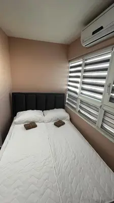 a large white bed in a room with windows at A tiny single room - Macchiato in Belgrade