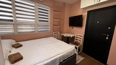 a bedroom with a bed and a tv and a window at A tiny single room - Macchiato in Belgrade
