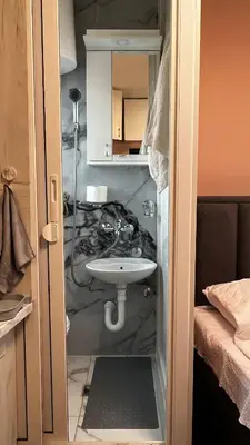a small bathroom with a sink in a room at A tiny single room - Macchiato in Belgrade