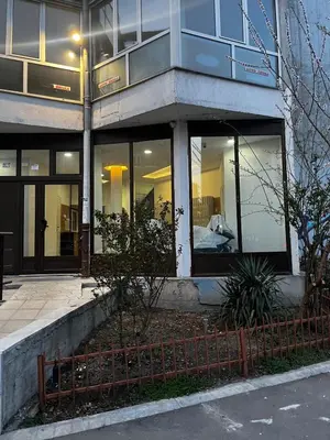 a building with glass windows and a fence in front of it at A tiny single room - Macchiato in Belgrade
