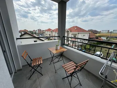 a balcony with two chairs and a table on it at Belgrade Airport Beds in Surčin