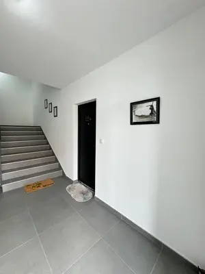 a white room with a staircase and a black door at Belgrade Airport Beds in Surčin