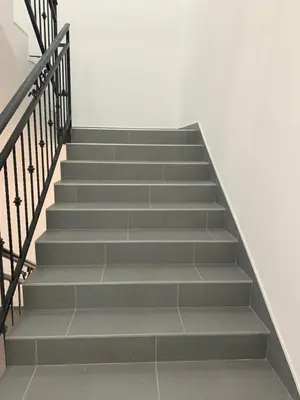 a staircase with grey steps and a white wall at Belgrade Airport Beds in Surčin