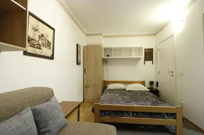 a small bedroom with a bed and a chair at Studio Apartman Valdez 1 in Belgrade
