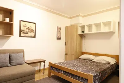 a small bedroom with a bed and a couch at Studio Apartman Valdez 1 in Belgrade