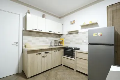 a kitchen with white cabinets and a refrigerator at Studio Apartman Valdez 1 in Belgrade